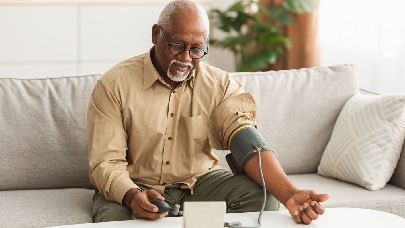 hypertension - senior black man checks his pressure